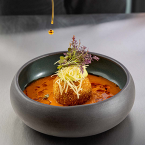 Krem pomidorowy/ arancini z ricottą i karczochem/ olej paprykowy/ Grana Padano